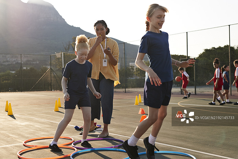女教练在训练女学生时吹哨子图片素材