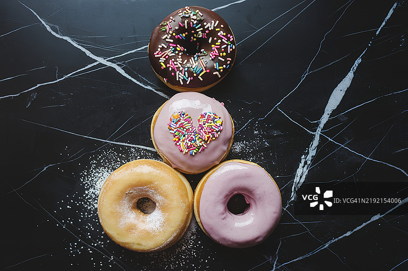 一张黑色大理石表面上放着三个甜甜圈的照片图片素材