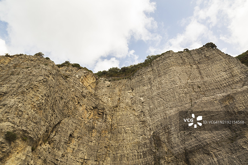 从低角度看崎岖陡峭的悬崖，切割的岩石面，意大利坎帕尼亚地区索伦托，欧洲图片素材