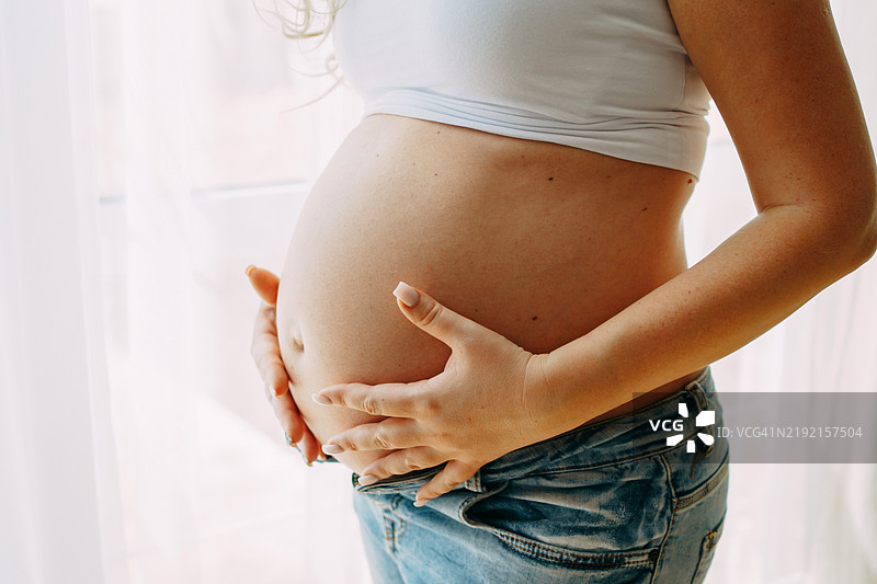 孕妇在窗边抱着肚子图片素材