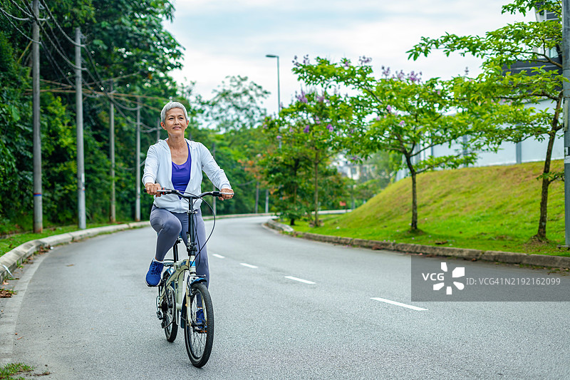 老年女性通过定期骑自行车保持身体强健图片素材