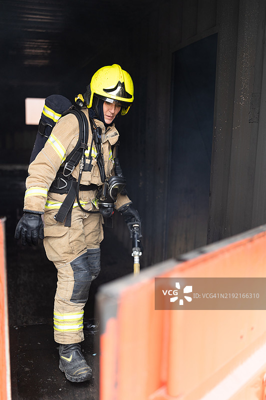 女消防员在消防演习中走出集装箱图片素材