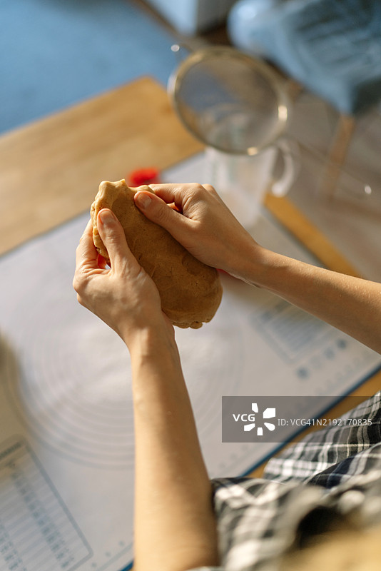 女人的手在桌子上拿着面包的特写图片素材