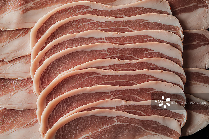 黑色背景上有多片粉红色的薄肉片图片素材