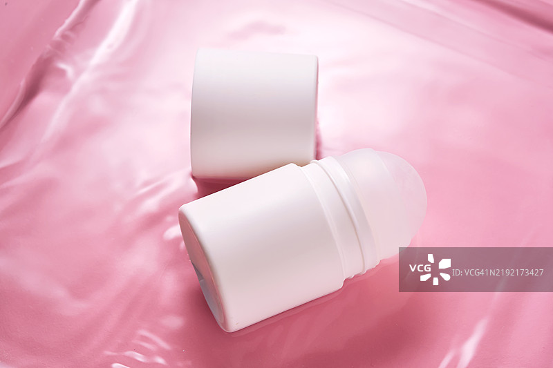 粉色背景下的水中滚珠香体露图片素材