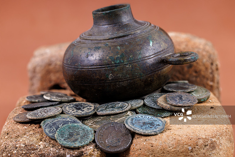 岩石上的硬币和茶壶特写镜头图片素材