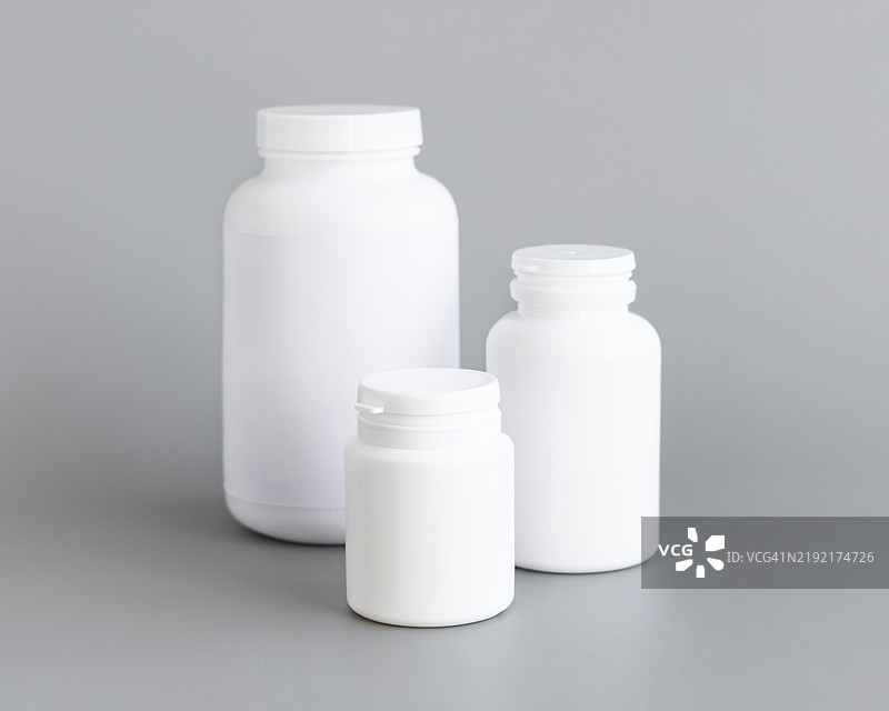白色塑料药瓶特写，背景为灰色，医疗概念模型，草本补充剂图片素材