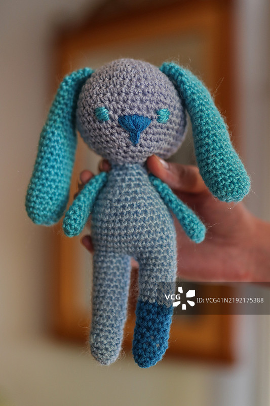 手中握着的钩针编织兔子玩具特写图图片素材