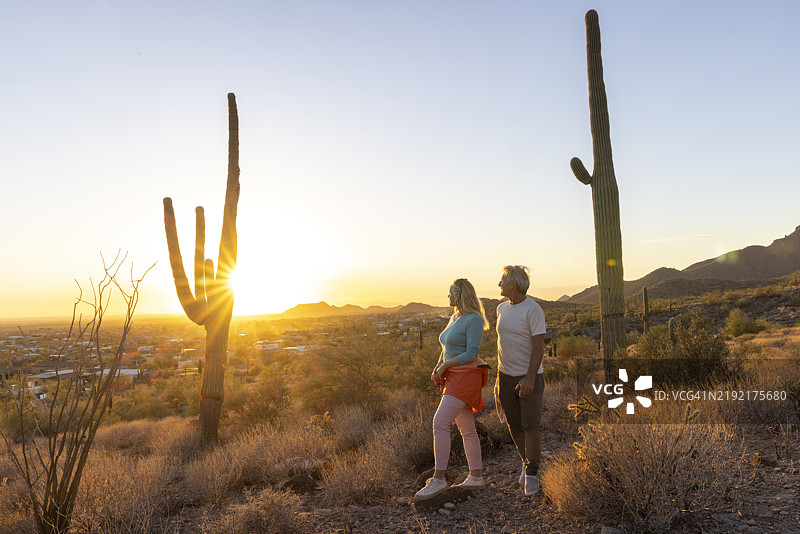 成熟夫妇在日落时分探索沙漠风光图片素材
