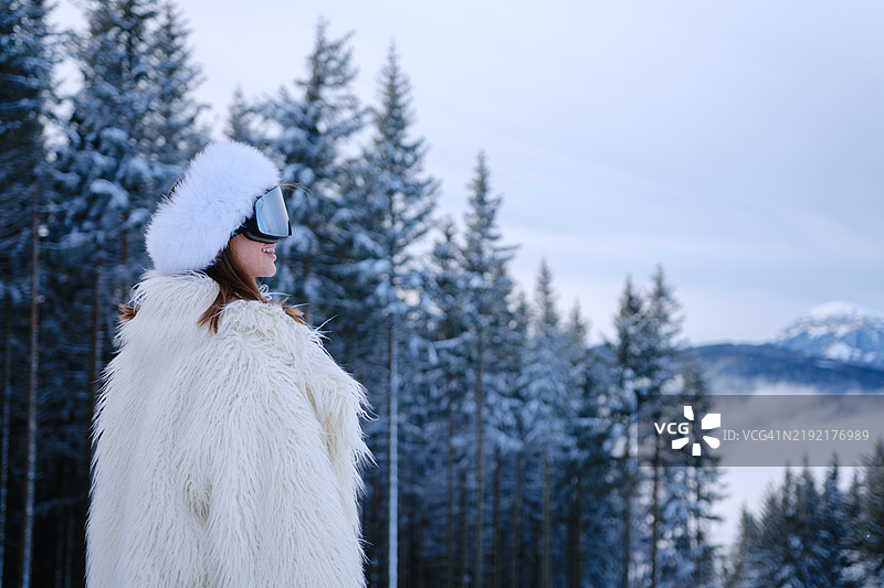 美丽年轻女性穿着奢华的滑雪后服装的肖像图片素材