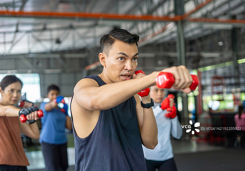 健身教练在举重课程中进行泰拳搏击操图片素材