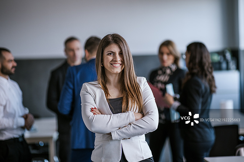 自信的女商人在专业的办公室环境中与同事们一起工作图片素材
