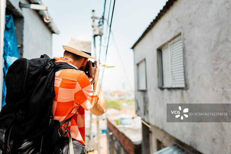 中年旅行者在巴西的贫民窟拍照图片素材