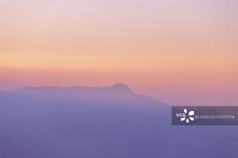 山间日出的柔和色调：雾气与光线的层次图片素材