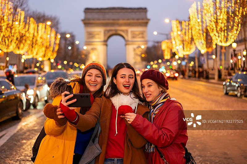 朋友们在节日的城市街道上自拍图片素材