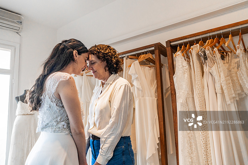 新娘和母亲在婚纱店面对面图片素材