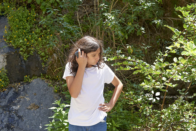 青少年男孩在森林中听对讲机，进行末日准备。图片素材