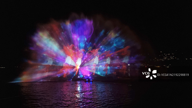 意大利北部的马焦雷湖（Lake Maggiore）上，圣诞主题的激光灯光投影，位于韦尔巴尼亚·帕兰扎（Verbania Pallanza）。这是联合国教科文组织的提契诺·瓦尔格兰德·韦尔巴诺生物圈保护区的一部分。图片素材