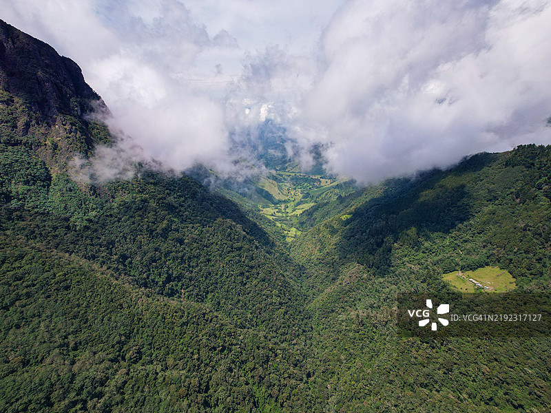 在哥伦比亚昆迪奥的萨伦托，绿色山脉被农作物环绕，天空略显多云。图片素材