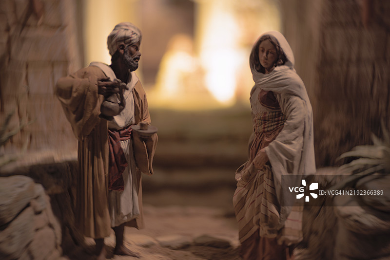 拿着水罐的村民与耶稣诞生场景图片素材