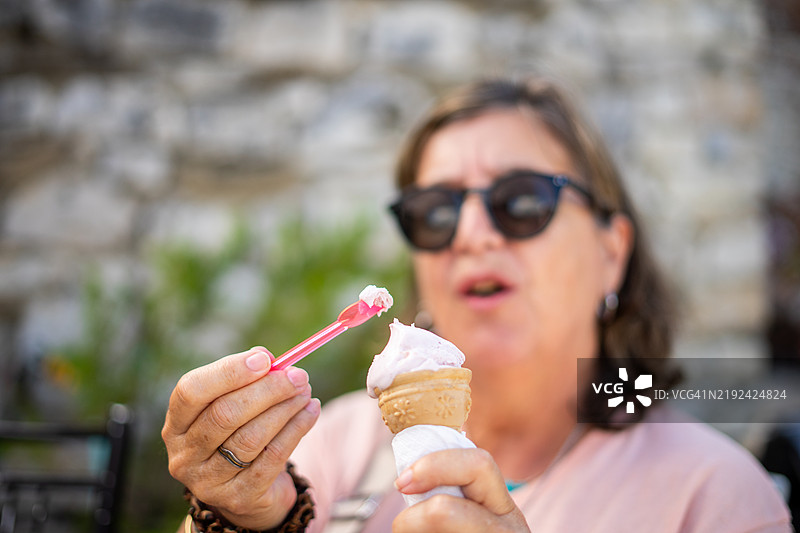 成熟的女性在阳光明媚的日子里享受冰淇淋图片素材