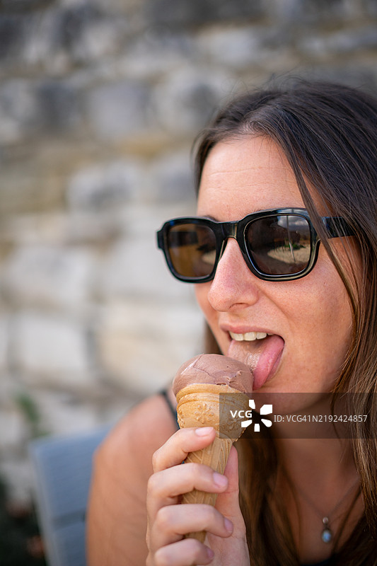 年轻女性在户外享受巧克力冰淇淋图片素材