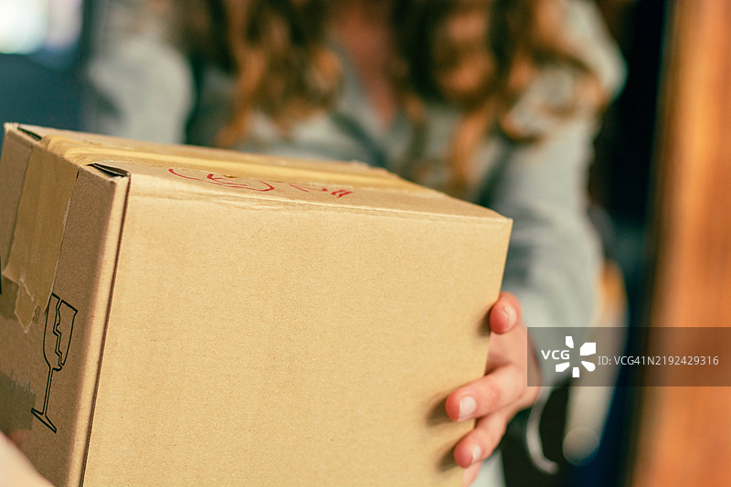 年轻女性正在递送纸箱的特写镜头图片素材