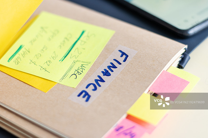 跟踪股市活动 - 带有注释便签的记事本，显示最近的股票报价图片素材