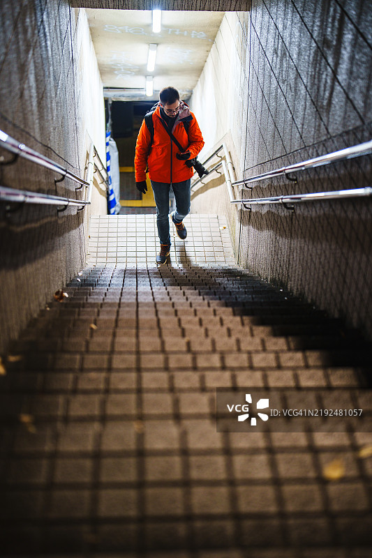 一个人在东京的地铁站夜晚独自爬楼梯。图片素材