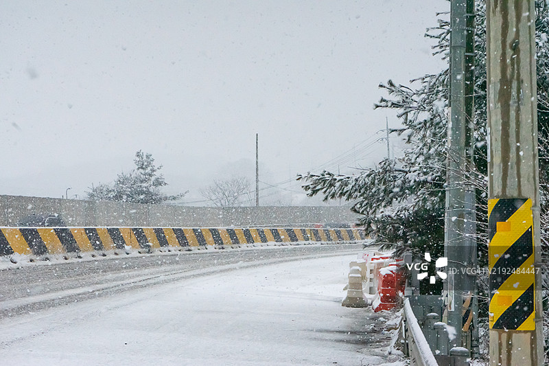 覆盖雪的道路，带有护栏和冬季氛围。图片素材