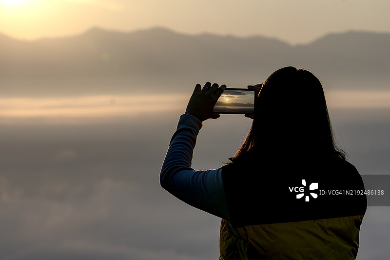 一位女徒步旅行者用手机拍照图片素材