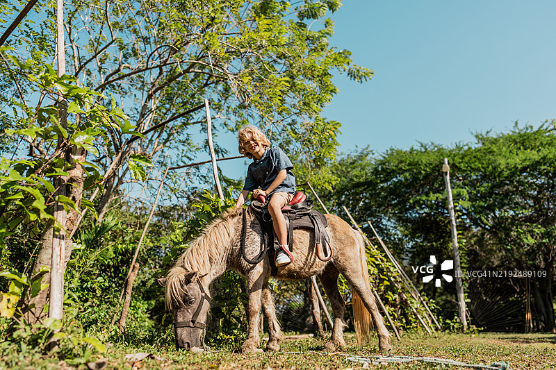 农舍里骑马的孩子肖像图片素材