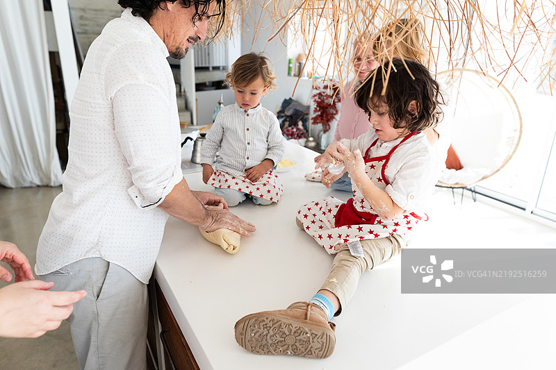 快乐的家庭在厨房一起制作比萨面团图片素材