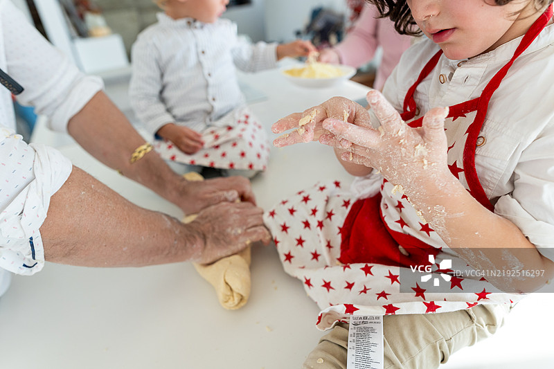 男孩正在清理粘在手上的披萨面团图片素材
