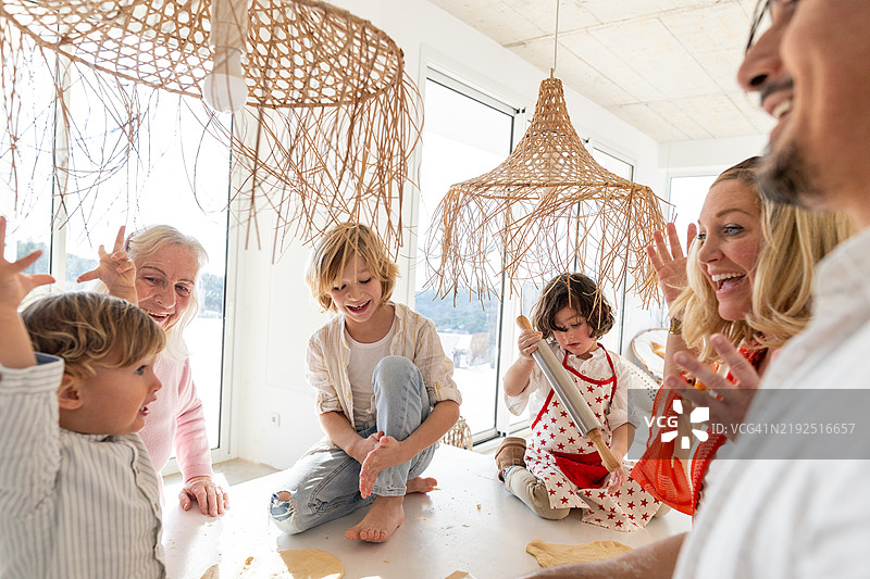 快乐的家庭在厨房一起制作比萨面团图片素材