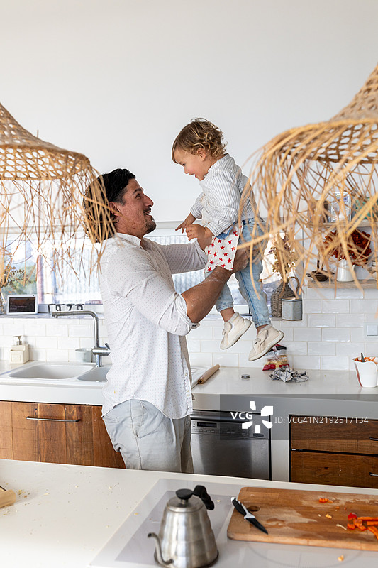 快乐的父亲在厨房里和女儿玩耍图片素材