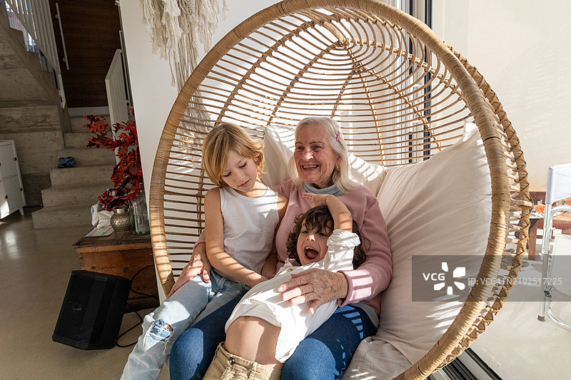 祖母和孙子孙女们在吊椅上欢笑在一起图片素材