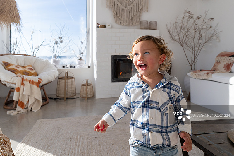 快乐的幼儿在家中探索客厅图片素材