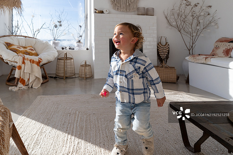 快乐的幼儿在现代客厅里奔跑图片素材