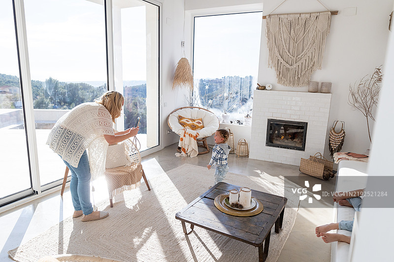 母亲在客厅拍摄她的孩子们玩耍的照片图片素材