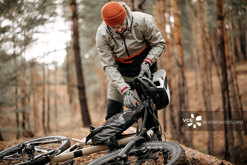 一个男人在准备他的自行车。图片素材