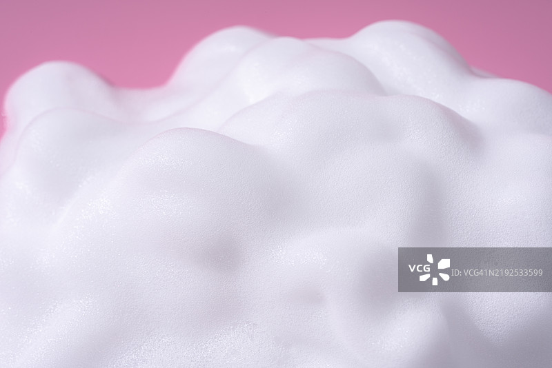 粉色背景上的白色肥皂泡沫图片素材