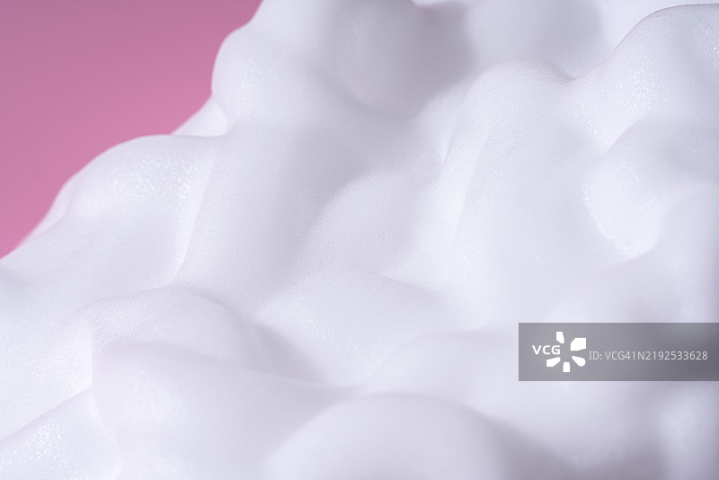 粉色背景上的白色肥皂泡沫图片素材