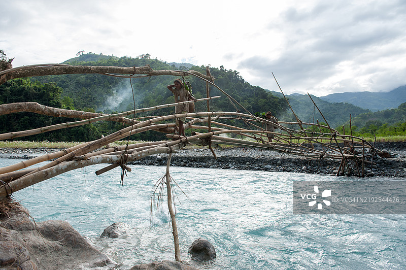 Mangyan原住民在河上走过竹桥图片素材
