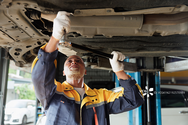 汽车修理工在升降机下方工作图片素材
