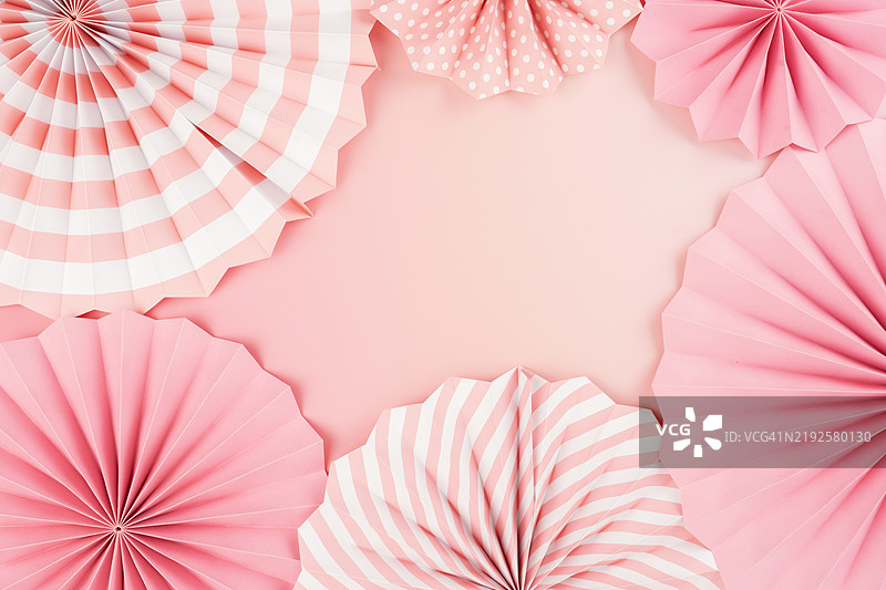 粉色和白色纸扇在粉色背景上，留有空白，适合节日和庆祝活动的背景装饰。图片素材