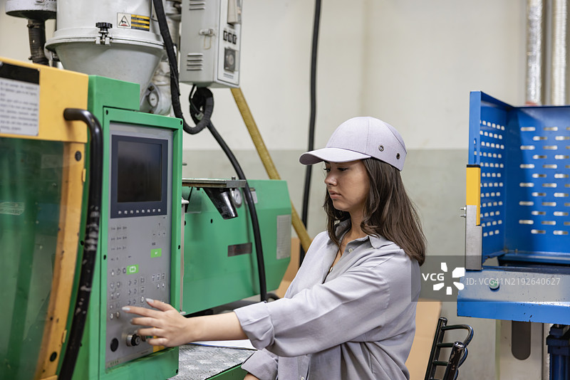 工业厂房女员工操作机器图片素材