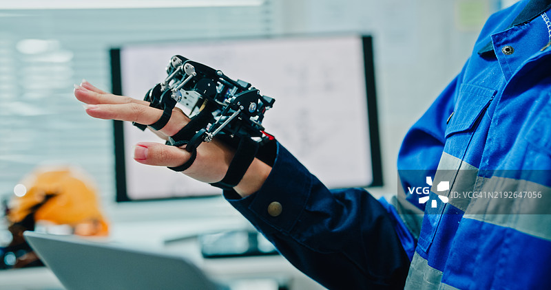 年轻女性工程师在科技实验室操作机器人手臂，进行人工智能和机器学习开发。人工智能与机器人技术开发。图片素材