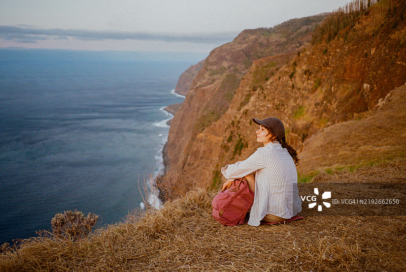 坐着的女性凝视着马德拉岛上大西洋的壮丽景色，拍摄于胶卷上图片素材