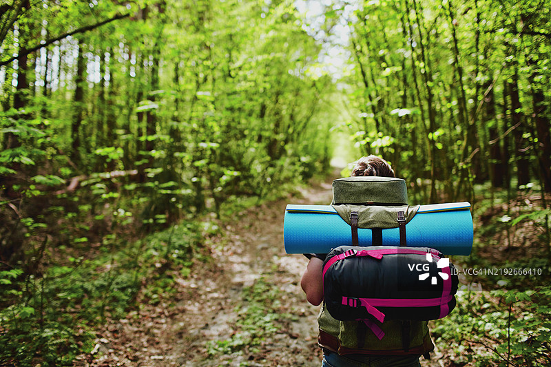 背包客在森林中徒步旅行，准备在大自然中露营图片素材